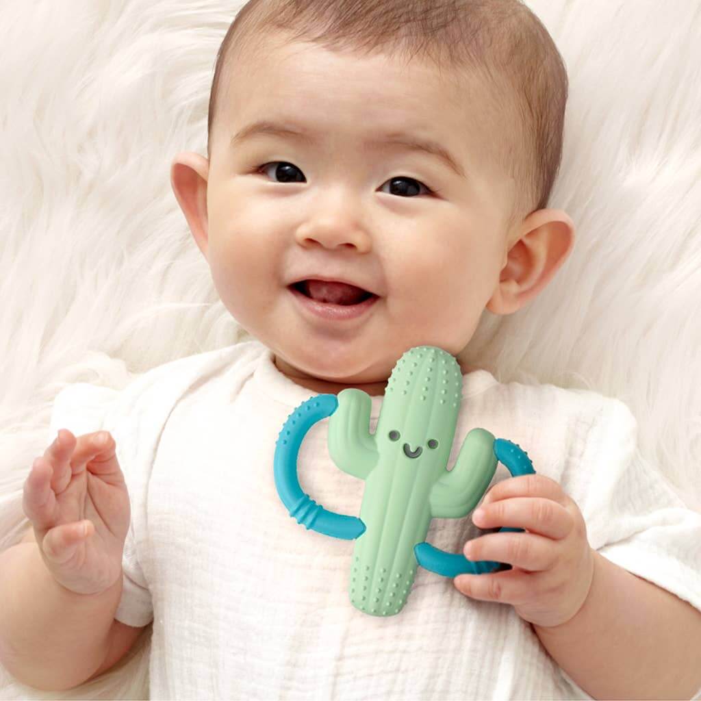 Baby holding Itzy Ritzy's Cooper the Cactus silicone teether with easy-to-hold handles for teething relief.